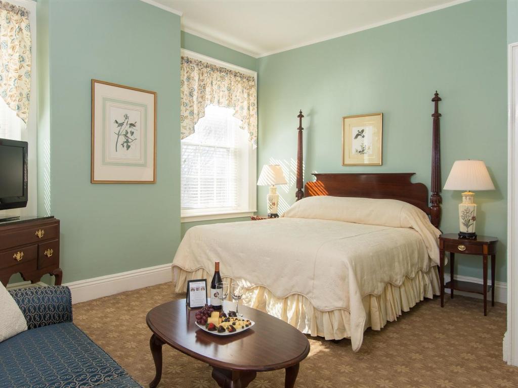 A bedroom with a  large bed with white bedding and a wooden headboard.
