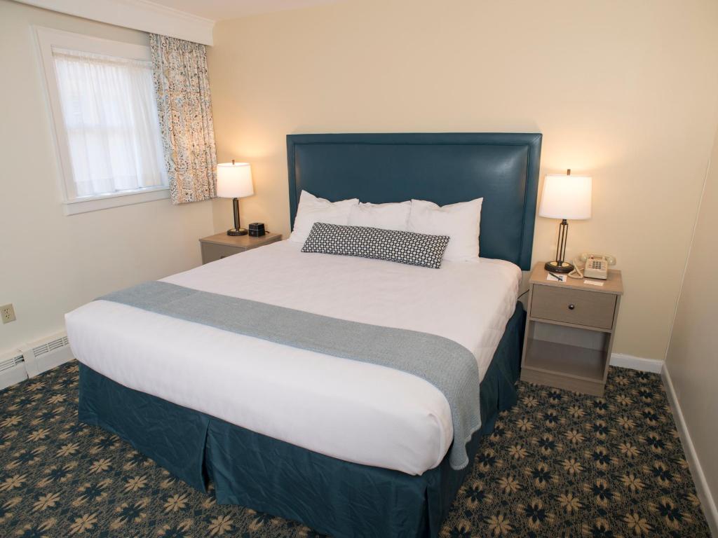 A room with a bed in the middle with blue and white bedding.
