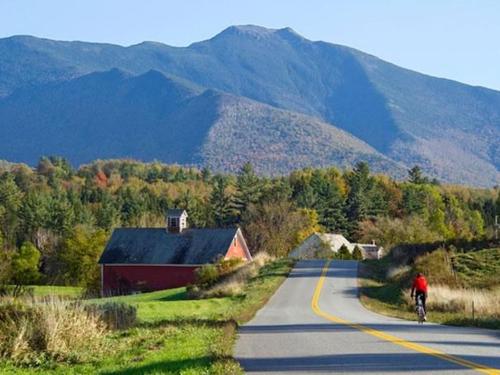 A hiker rides down an empty road towards mountains