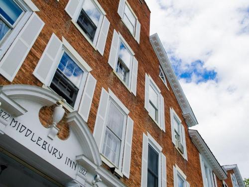 Exterior building that is brick with white shutters on the windows.